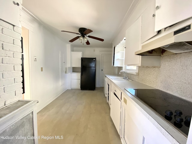 kitchen featuring white cabinetry, sink, black fridge, light hardwood / wood-style flooring, and white electric stovetop