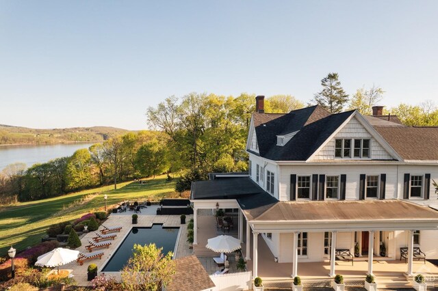 152 William St, Catskill, NY 12414 - back of house featuring an infinity pool, a water view, a chimney, and covered porch