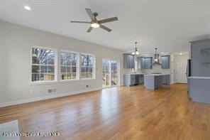 unfurnished living room with light wood-style flooring, baseboards, ceiling fan, and recessed lighting