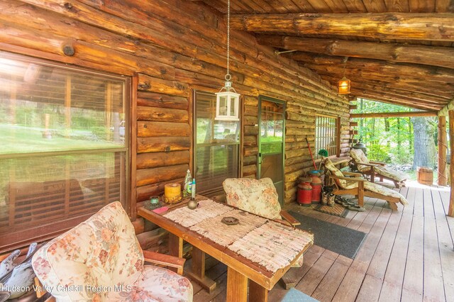 sunroom featuring wood ceiling and lofted ceiling with beams