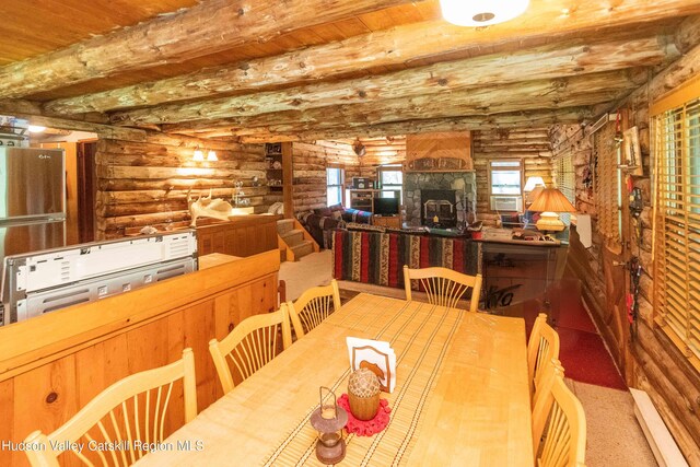 dining room featuring log walls, a baseboard heating unit, carpet flooring, and beamed ceiling