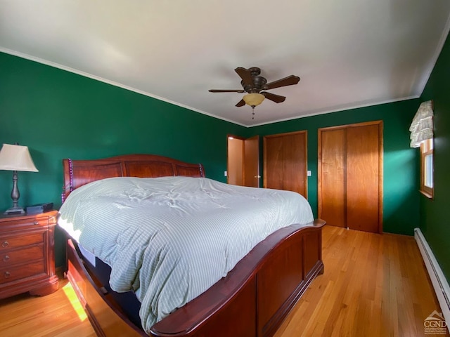 20 Joslen Pl, Hudson, NY 12534 - bedroom featuring baseboard heating, light wood finished floors, two closets, a ceiling fan, and baseboards