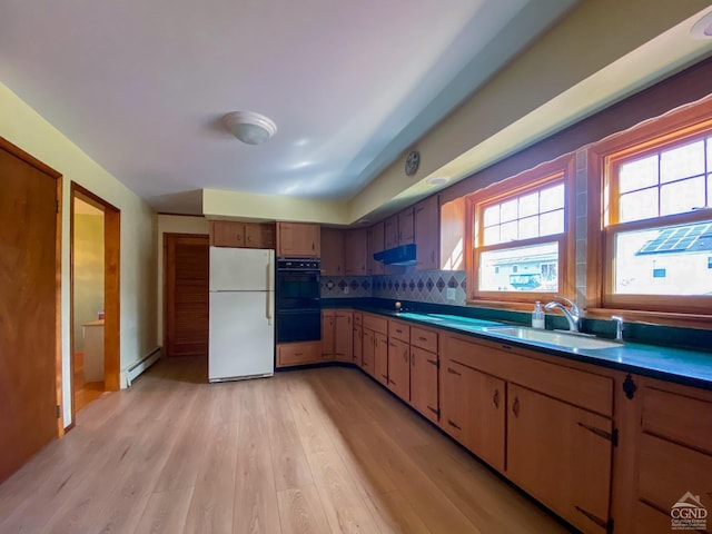 20 Joslen Pl, Hudson, NY 12534 - kitchen featuring freestanding refrigerator, a sink, baseboard heating, light wood-style flooring, and tasteful backsplash
