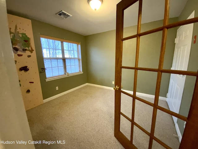 spare room featuring baseboards and visible vents