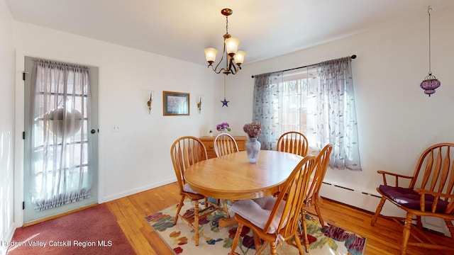 dining area featuring hardwood / wood-style flooring, a wealth of natural light, and a chandelier