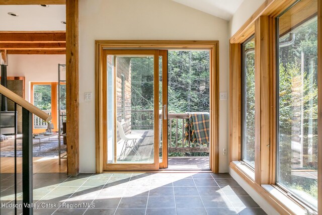 entryway featuring tile patterned floors and vaulted ceiling