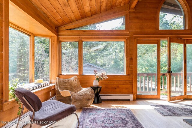 sunroom with lofted ceiling with beams, a wealth of natural light, and a baseboard radiator