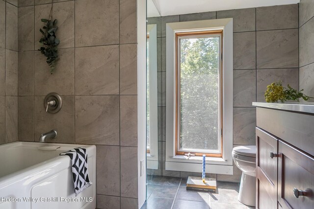 bathroom featuring tile patterned flooring, vanity, toilet, and tile walls