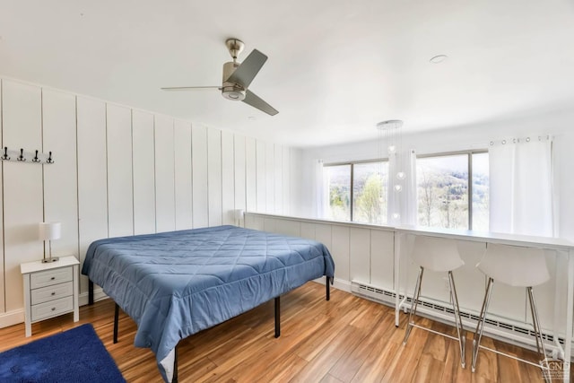 59 Scribner Hollow Rd # B-2, Hunter, NY 12442 - bedroom with a baseboard heating unit, wood finished floors, and a ceiling fan