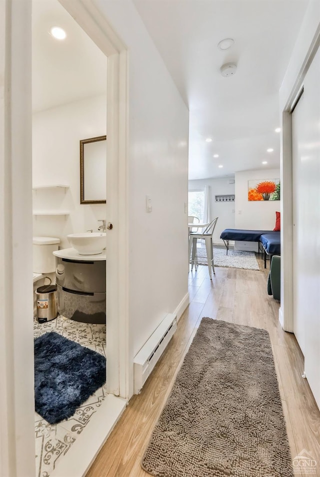 59 Scribner Hollow Rd # B-2, Hunter, NY 12442 - corridor with a baseboard heating unit, a sink, light wood finished floors, and recessed lighting
