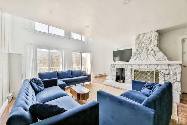 59 Scribner Hollow Rd # B-2, Hunter, NY 12442 - living area featuring a baseboard radiator, wood finished floors, and a stone fireplace