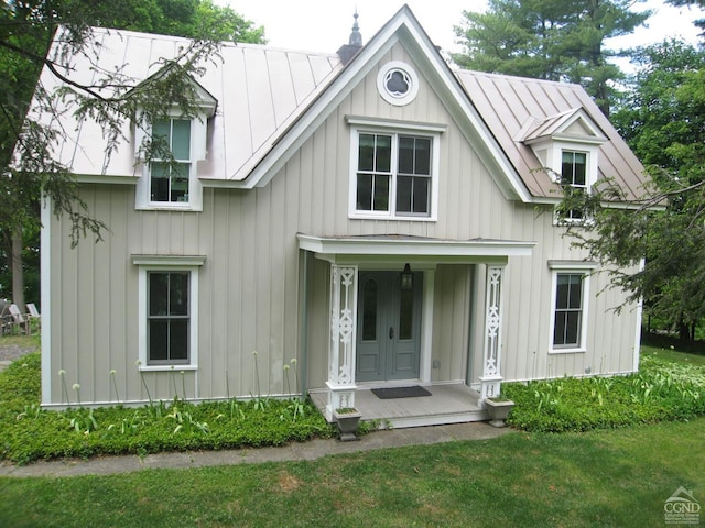 modern farmhouse style home featuring board and batten siding, metal roof, covered porch, and a standing seam roof