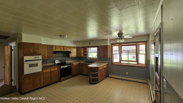 183 S St, Windham, NY 12496 - kitchen with stainless steel range with electric stovetop, white oven, baseboard heating, under cabinet range hood, and light flooring