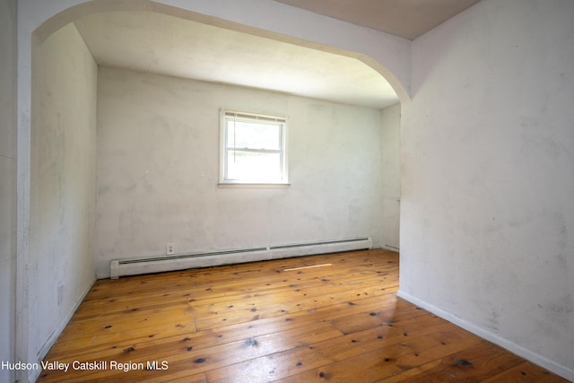 273 Round Top Rd, Germantown, NY 12526 - spare room featuring arched walkways, a baseboard radiator, and wood-type flooring