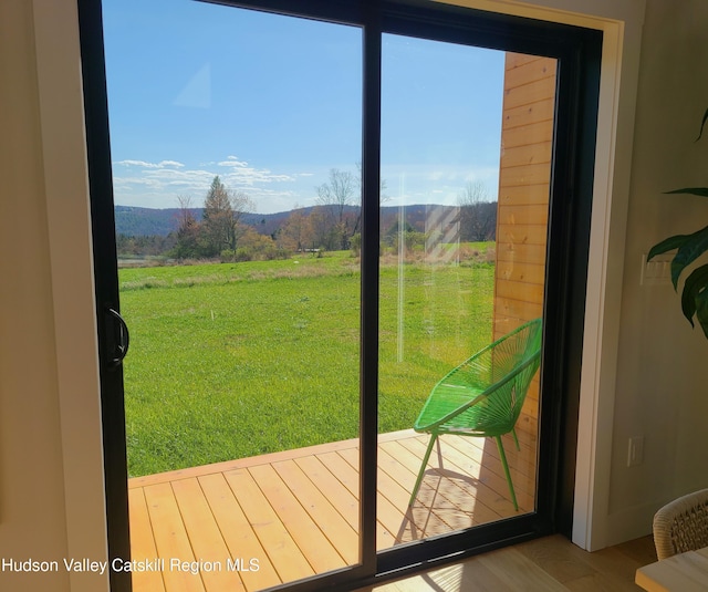 doorway with a mountain view, a rural view, and wood-type flooring