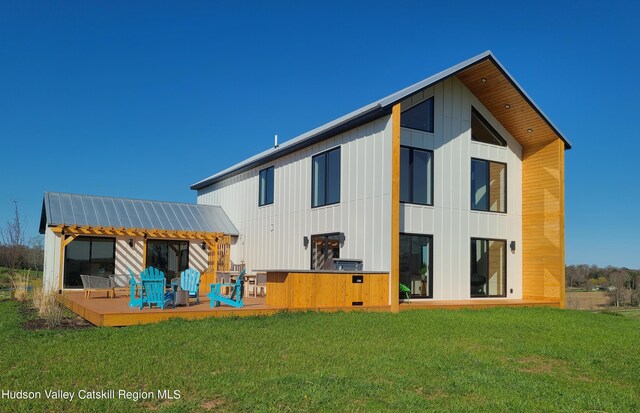 rear view of house with a wooden deck and a yard