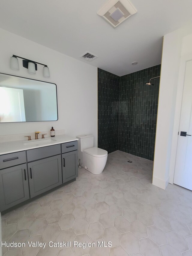 bathroom with tile patterned flooring, vanity, toilet, and walk in shower