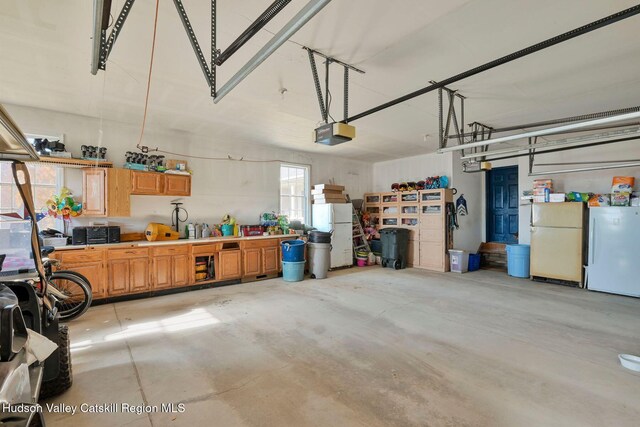 garage with white refrigerator and a garage door opener