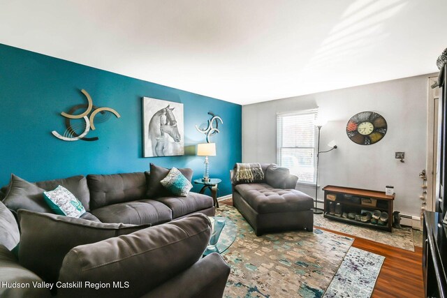 living room featuring hardwood / wood-style floors and a baseboard heating unit