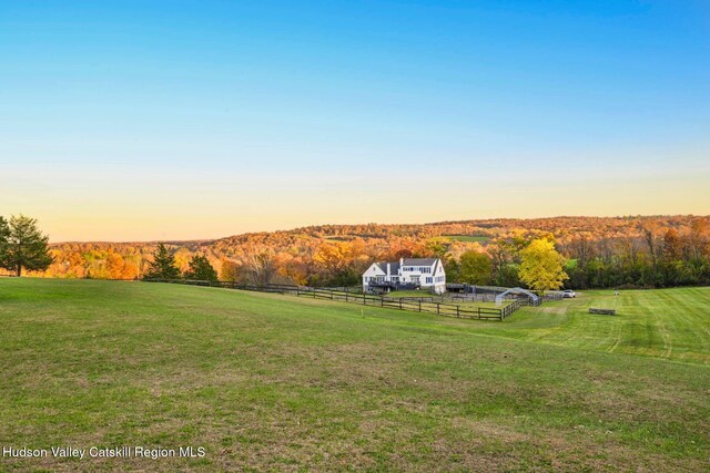 yard at dusk with a mountain view and a rural view