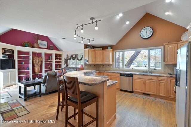 kitchen featuring stainless steel dishwasher, decorative backsplash, light hardwood / wood-style floors, and light stone countertops