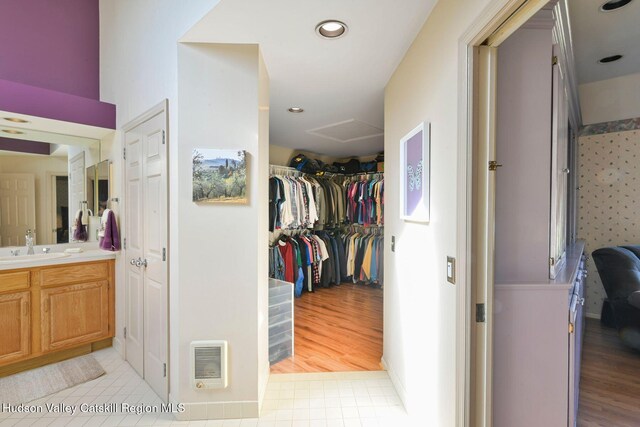 bedroom with ensuite bath, ceiling fan, and light wood-type flooring