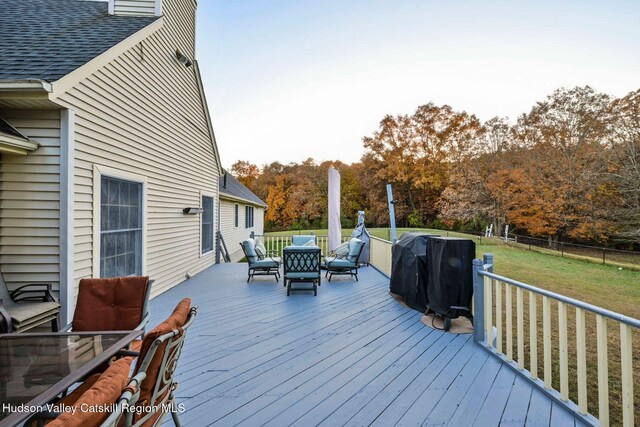 deck featuring area for grilling and a lawn