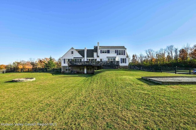 rear view of house featuring a yard and a deck