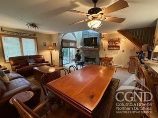 274 Brooksburgh Rd Unit 10, Windham, NY 12496 - dining room with a large fireplace, ceiling fan, and plenty of natural light