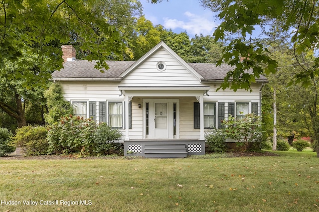 55 Church Ave, Germantown, NY 12526 - view of front of home featuring a front yard, a chimney, roof with shingles, and a porch
