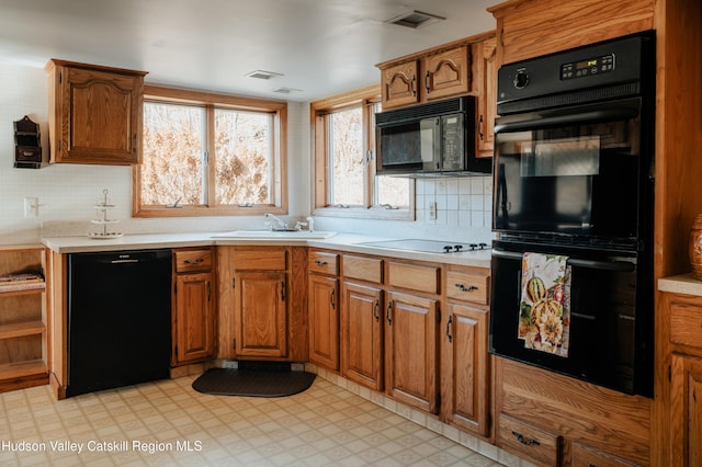 kitchen with black appliances, decorative backsplash, and sink