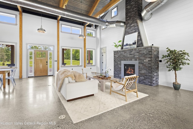 1248 Albany Post Rd, Gardiner, NY 12525 - living area featuring speckled floor, a towering ceiling, and a fireplace