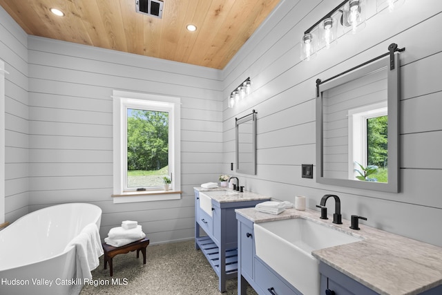 1248 Albany Post Rd, Gardiner, NY 12525 - bathroom featuring wooden ceiling, recessed lighting, two vanities, speckle patterned floor, and a freestanding bath