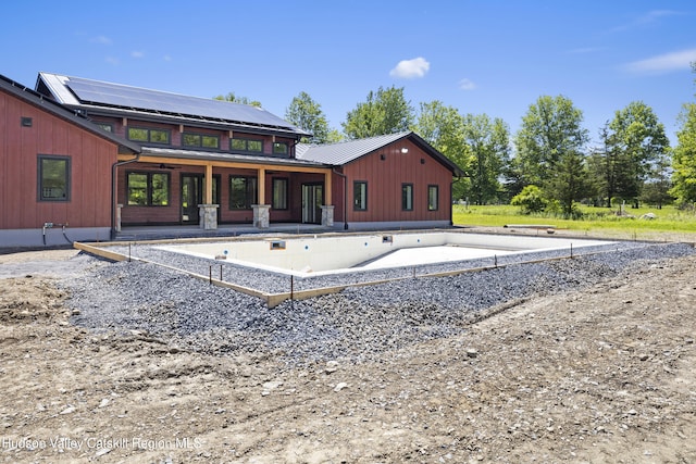 1248 Albany Post Rd, Gardiner, NY 12525 - rear view of house featuring a patio area, metal roof, and solar panels