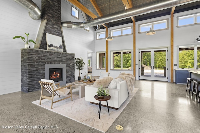 1248 Albany Post Rd, Gardiner, NY 12525 - living area featuring a towering ceiling, speckled floor, a fireplace, french doors, and plenty of natural light