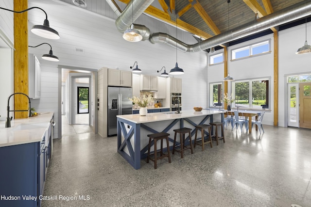 1248 Albany Post Rd, Gardiner, NY 12525 - kitchen featuring appliances with stainless steel finishes, a high ceiling, a sink, blue cabinets, and light countertops