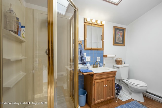 full bathroom with toilet, baseboard heating, a shower stall, vanity, and decorative backsplash