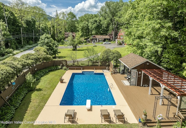 view of swimming pool featuring a diving board, a fenced backyard, a lawn, a patio area, and a fenced in pool