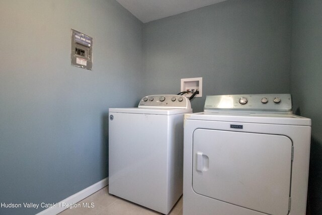 washroom with washing machine and dryer and light tile patterned floors