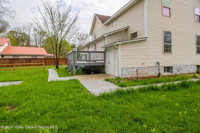 exterior space featuring a lawn and a deck