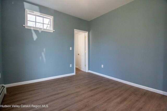 spare room featuring dark hardwood / wood-style flooring and a baseboard radiator