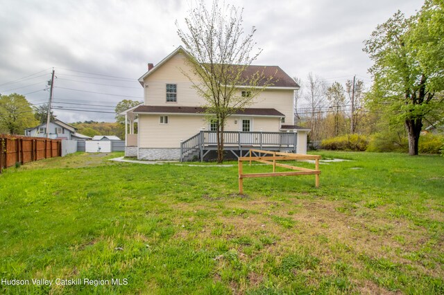 rear view of property featuring a yard and a deck