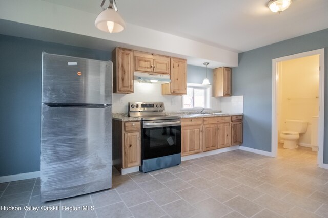 kitchen featuring light tile patterned floors, stainless steel appliances, hanging light fixtures, and sink