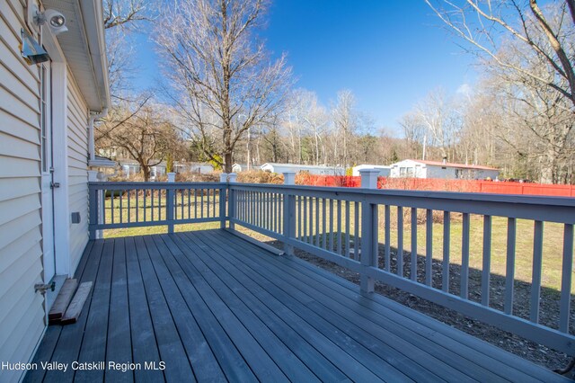 wooden deck featuring a lawn