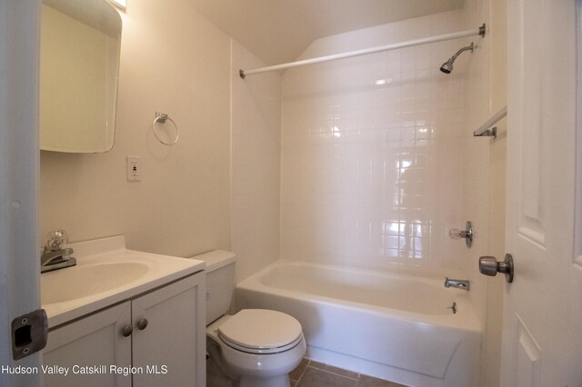 full bathroom with tile patterned floors, vanity, tiled shower / bath combo, and toilet