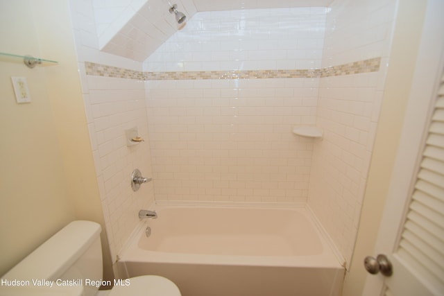 bathroom featuring toilet and tiled shower / bath combo