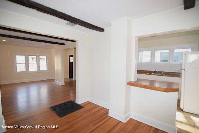 interior space with sink, hardwood / wood-style floors, and beam ceiling