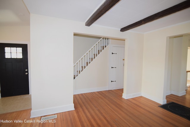 entryway with beam ceiling and hardwood / wood-style floors