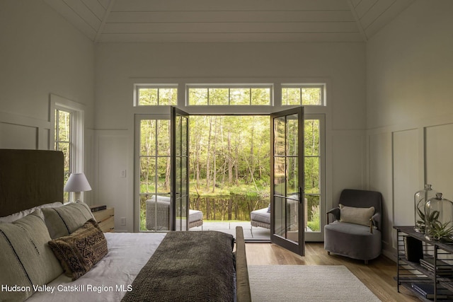 245 Brown Rd, Olivebridge, NY 12461 - bedroom featuring a decorative wall, lofted ceiling, wood finished floors, access to outside, and wainscoting
