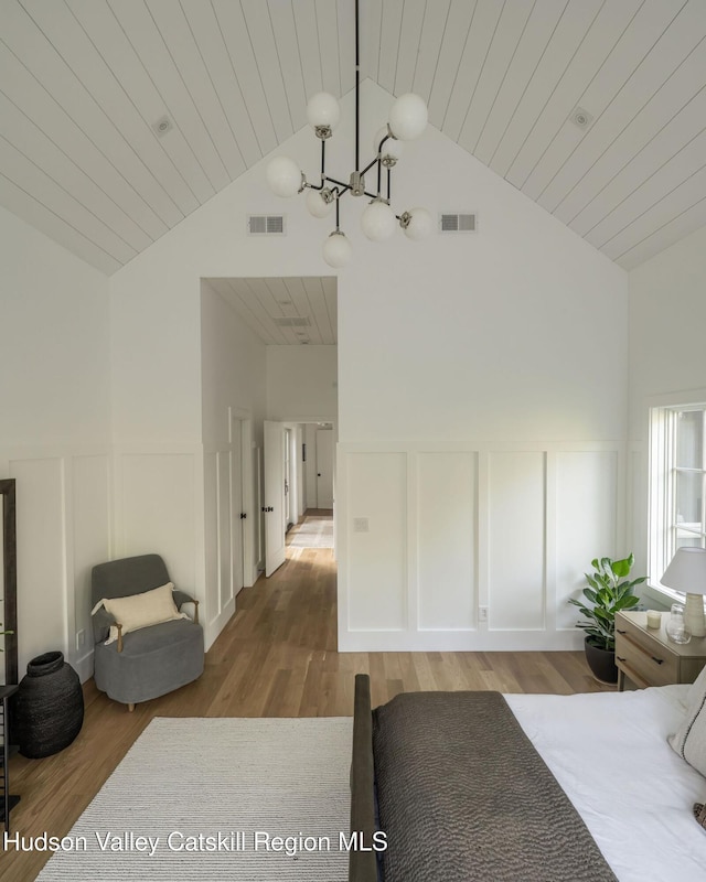 245 Brown Rd, Olivebridge, NY 12461 - bedroom featuring a decorative wall, a chandelier, wood finished floors, wainscoting, and wooden ceiling
